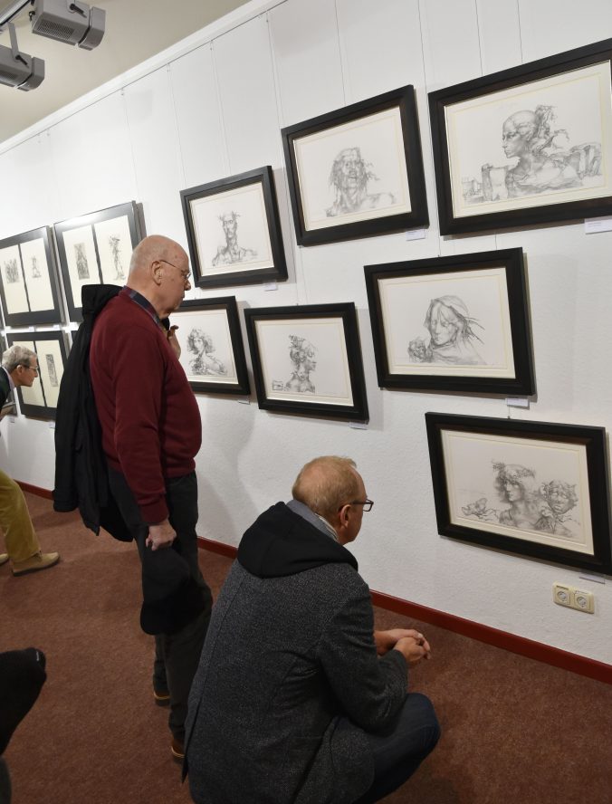 Gäste der Vernissage betrachten Zeichnungen von Heinz Zander zu "Tristan und Isolde".